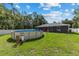 Backyard with above-ground pool, surrounded by white fence and lush green grass at 6 Sequoia Loop, Ocklawaha, FL 32179