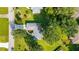 An aerial view showcases a home with a lush green yard, mature trees and a vibrant, colorful garden feature at 6113 Sw 101St Pl, Ocala, FL 34476