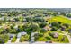 An aerial view showcases a neighborhood with well-maintained homes, green lawns, and mature trees under a sunny sky at 6113 Sw 101St Pl, Ocala, FL 34476