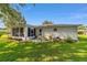 The home's backyard features a screened patio, an open stone patio and lush green lawn at 6113 Sw 101St Pl, Ocala, FL 34476