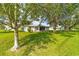 The backyard showcases a well-manicured lawn and the rear of the home with a screened patio at 6113 Sw 101St Pl, Ocala, FL 34476