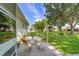 The backyard features a stone patio with outdoor seating, surrounded by lush green lawn and mature trees at 6113 Sw 101St Pl, Ocala, FL 34476