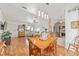 Bright dining area with wooden table set, modern lighting, and an open view to living room and kitchen at 6113 Sw 101St Pl, Ocala, FL 34476
