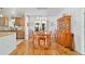 Bright dining room with hardwood floors, wooden table and view into the kitchen at 6113 Sw 101St Pl, Ocala, FL 34476