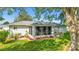 Exterior view of the rear of the house showcasing a screened patio and landscaped yard at 6113 Sw 101St Pl, Ocala, FL 34476