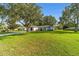 Inviting single-story home with a lush green lawn and mature trees at 6113 Sw 101St Pl, Ocala, FL 34476