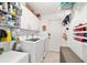 Laundry room features modern appliances, white cabinets, and open shelves for storage, plus a door to the outside at 6113 Sw 101St Pl, Ocala, FL 34476