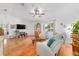 Open living room featuring hardwood floors, natural lighting, and comfortable furniture at 6113 Sw 101St Pl, Ocala, FL 34476