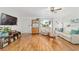 Bright living room with wood floors, white walls, and a decorative display cabinet at 6113 Sw 101St Pl, Ocala, FL 34476