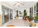 Bright sunroom filled with natural light features many potted plants and access to the backyard through a sliding door at 6113 Sw 101St Pl, Ocala, FL 34476