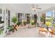 Bright sunroom filled with natural light features many potted plants and a ceiling fan at 6113 Sw 101St Pl, Ocala, FL 34476