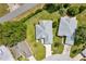 Aerial view of a home with well-maintained landscaping, a driveway, a gray roof, and a verdant backyard at 6330 Sw 117Th Loop, Ocala, FL 34476