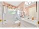 Bright bathroom featuring a tub-shower combo with a glass door, vanity, and tasteful decor at 6330 Sw 117Th Loop, Ocala, FL 34476
