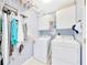Laundry room with a washer, a dryer, white cabinets, light blue walls, and cleaning supplies at 6330 Sw 117Th Loop, Ocala, FL 34476