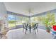 Screened-in sunroom with tile floors, a ceiling fan, many windows, patio furniture, and decorative plates on the walls at 6330 Sw 117Th Loop, Ocala, FL 34476