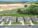 Overhead view of a residential area showing a neat street and manicured lawns near a highway and green trees at 7067 Sw 60Th Ln, Ocala, FL 34474