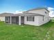 Exterior of home with a screened-in lanai and grassy lawn and blue skies at 7067 Sw 60Th Ln, Ocala, FL 34474