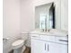 Bathroom featuring modern vanity with sink, toilet, framed mirror and wood look flooring at 7067 Sw 60Th Ln, Ocala, FL 34474