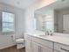 Bright bathroom featuring a modern vanity with sink, toilet, and large mirror at 7067 Sw 60Th Ln, Ocala, FL 34474