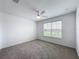 Bedroom featuring a ceiling fan, neutral carpet, a window, and white walls at 7067 Sw 60Th Ln, Ocala, FL 34474