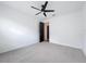 Bright bedroom with a modern ceiling fan, gray carpet, and a door leading to the next room at 7067 Sw 60Th Ln, Ocala, FL 34474