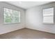 Bright bedroom featuring wood-look flooring and two windows offering ample natural light at 7067 Sw 60Th Ln, Ocala, FL 34474