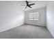 Bright bedroom with a modern ceiling fan, gray carpet, and a window providing natural light at 7067 Sw 60Th Ln, Ocala, FL 34474