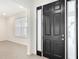 Entryway featuring a black front door with sidelights, leading into a room with large window and tile flooring at 7067 Sw 60Th Ln, Ocala, FL 34474