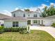 Inviting two-story home with a well-maintained lawn, lush landscaping, and a covered front porch at 7067 Sw 60Th Ln, Ocala, FL 34474