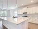 Bright kitchen with white cabinetry, an island with a marble countertop, and modern pendant lighting at 7067 Sw 60Th Ln, Ocala, FL 34474