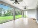 Relaxing screened lanai with ceiling fans, offering views of the green backyard at 7067 Sw 60Th Ln, Ocala, FL 34474