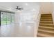 Open concept living area with tile flooring, stairs, a modern ceiling fan, and a view into the kitchen at 7067 Sw 60Th Ln, Ocala, FL 34474