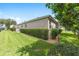 This home features a well-maintained backyard with a lush green lawn and manicured hedges at 7243 Se 172Nd Legacy Ln, The Villages, FL 32162
