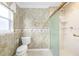 Well-lit bathroom featuring a shower with glass door and decorative wallpaper at 7243 Se 172Nd Legacy Ln, The Villages, FL 32162