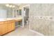 Bright bathroom with dual mirrors, wood cabinets and a view of the toilet at 7243 Se 172Nd Legacy Ln, The Villages, FL 32162
