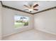 Bright bedroom featuring neutral walls, a ceiling fan, and a large window offering a view of the neighborhood at 7243 Se 172Nd Legacy Ln, The Villages, FL 32162