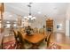 Dining room with decorative rug, seating for six, stylish chandelier, and open view of fireplace and kitchen at 7243 Se 172Nd Legacy Ln, The Villages, FL 32162