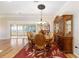Elegant dining room with a wooden china cabinet, seating for six, and access to a screened-in porch at 7243 Se 172Nd Legacy Ln, The Villages, FL 32162