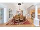 Formal dining room featuring a chandelier, decorative rug, and elegant mirrored wall decor for refined meals at 7243 Se 172Nd Legacy Ln, The Villages, FL 32162