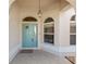 Close up shot of front door framed by arched windows and covered porch at 7243 Se 172Nd Legacy Ln, The Villages, FL 32162