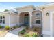 Charming home features an arched front entry with decorative lighting and a teal-colored front door at 7243 Se 172Nd Legacy Ln, The Villages, FL 32162