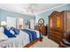 This bedroom features blue walls and a beautiful dark wood furniture set, creating a relaxing and stylish atmosphere at 7454 Sw 101St Ave, Ocala, FL 34481