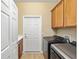 This laundry room features side by side washer and dryer, with added cabinet space and a door to the exterior at 7454 Sw 101St Ave, Ocala, FL 34481