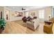 Open-concept living room with wood floors, comfortable sofas, and a pass-through to the kitchen at 7454 Sw 101St Ave, Ocala, FL 34481