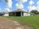 A view of the home from the backyard, showing a screened-in patio and landscaping at 80 Hickory Course Loop, Ocala, FL 34472