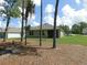 Lawn with trees, with the back of the house featuring multiple windows, visible at 80 Hickory Course Loop, Ocala, FL 34472