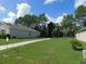 Spacious backyard featuring a well-maintained lawn and pathway leading to neighboring properties at 80 Hickory Course Loop, Ocala, FL 34472