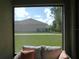 View of the backyard from the screened lanai, showcasing a spacious lawn and neighboring property at 80 Hickory Course Loop, Ocala, FL 34472