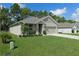 Well-maintained front yard of a cozy home with green lawn and landscape at 80 Hickory Course Loop, Ocala, FL 34472