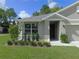 Inviting view of a home's entrance framed by lush, green landscaping at 80 Hickory Course Loop, Ocala, FL 34472